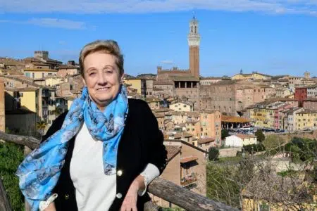 Anna Ferretti: “Fabio non sa che la destra taglia i finanziamenti alla sanità” Anna Ferretti con panorama di Siena sullo sfondo