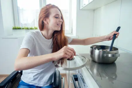 Asl Toscana sud est, disabilità: bando “Indipendenza e Autonomia InAut” 2023 Donna disabile in carrozzina in cucina
