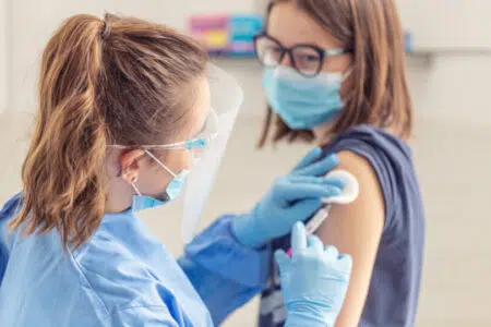 Vaccinazione antinfluenzale e contro il Covid-19, parte la campagna in Toscana Infermiera somministra con siringa vaccino Covid-19 a donna