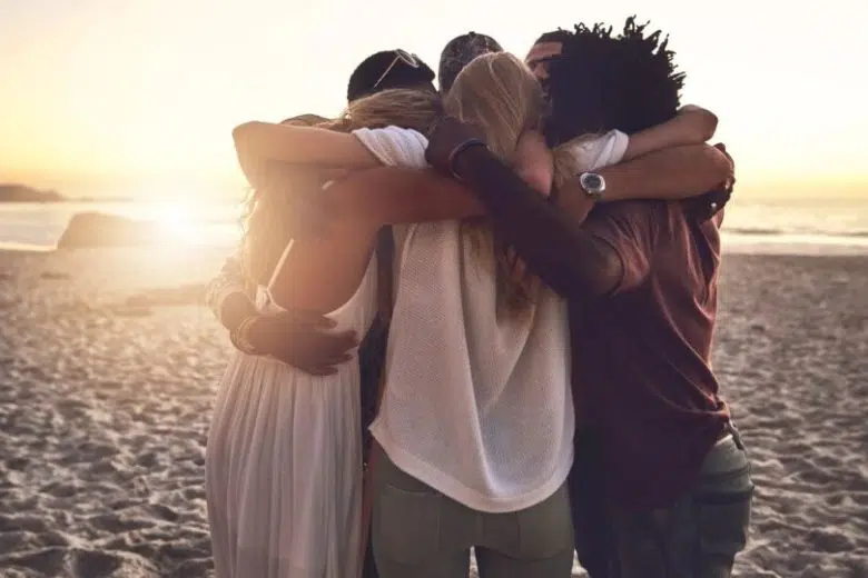 Caritas diocesana di Siena: evento per coinvolgere nuovi volontari Caritas Diocesana Siena, gruppo ragazzi abbracciati in spiaggia