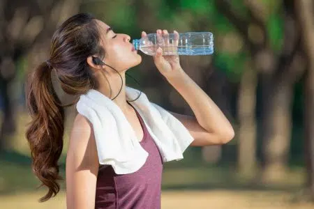 Come svolgere attività fisica in estate in totale sicurezza Attività fisica in estate, ragazza beve