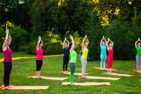 ‘A spasso per…’: nuovo appuntamento con trekking e yoga a Rapolano Yoga, donne su un prato